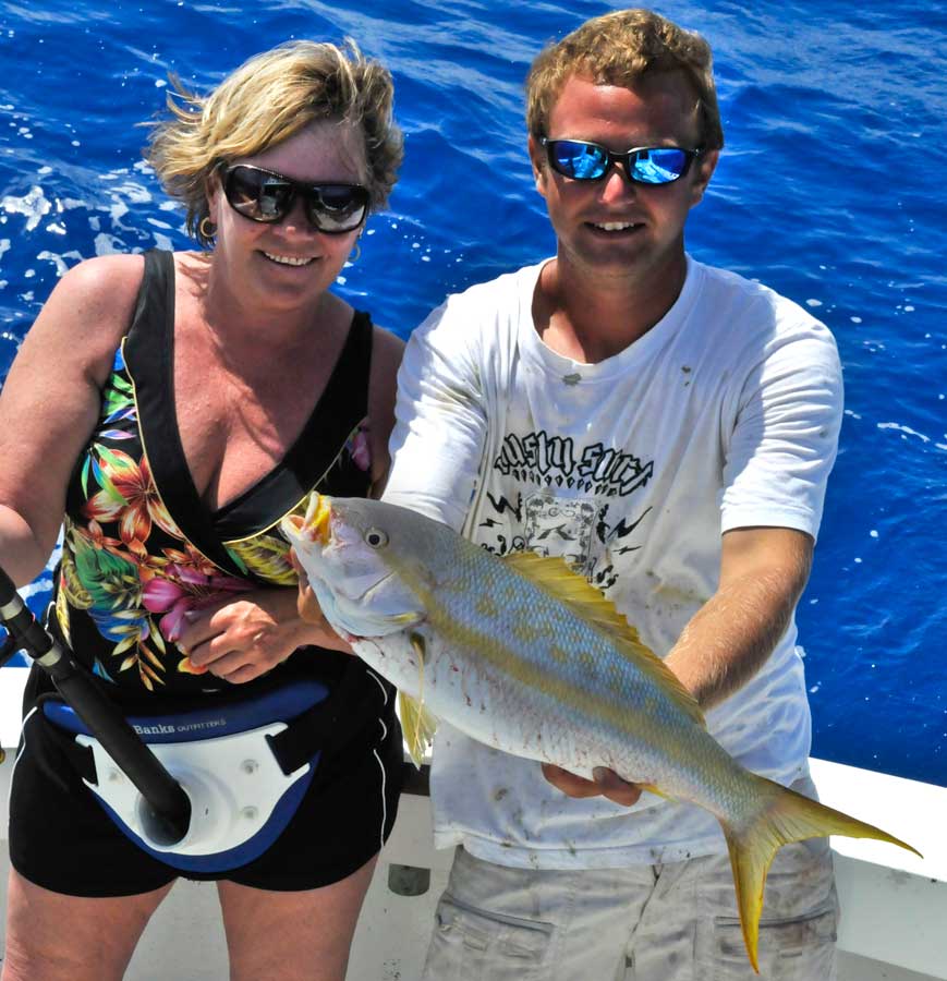 Eva with a huge Yellowtail Snapper held by Mate Alex Ross aboard the Restless Too
